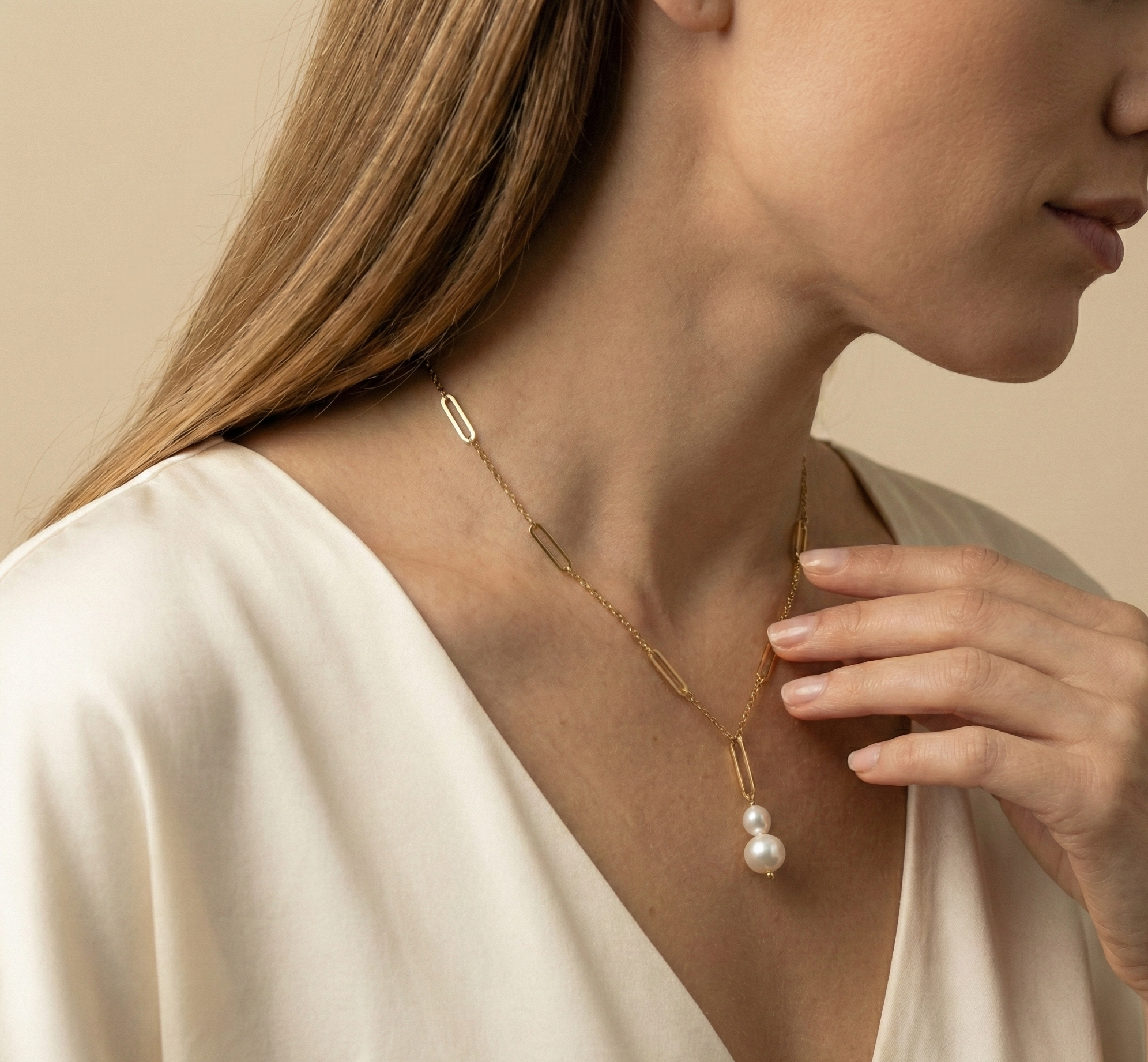 Elegant gold lariat style necklace with genuine freshwater baroque pearls. Minimalist bridal jewelry on a female model, highlighting high-luster pearl drop and modern gold link chain design