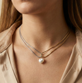 double-strand silver and gold snake chain necklace featuring a single lustrous white baroque pearl pendant