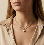 model wearing double-strand silver snake chain necklace featuring a single lustrous white baroque pearl pendant