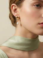 Alizee earrings featuring a textured 2.5cm gold disc stud with a dangling 8mm white baroque freshwater pearl. Artisan-style 18k gold plated jewelry