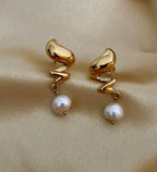 Close-up detail of the light-reflecting gold texture on Alizee earrings paired with a high-lustre AAA freshwater pearl