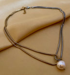 double-strand silver gold snake chain necklace featuring a single lustrous white baroque pearl pendant