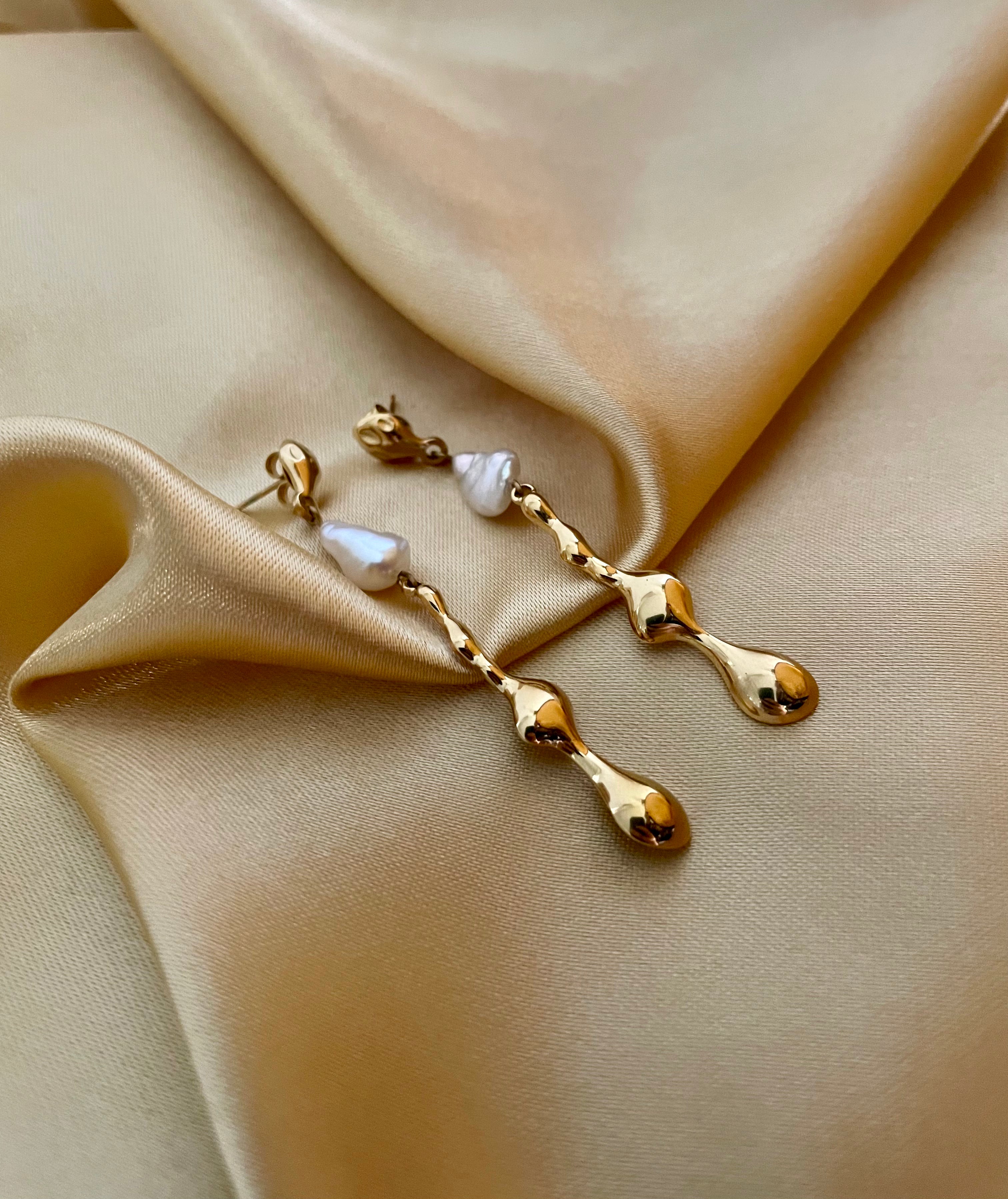 Détail d'une boucle d'oreille élégante en or et perle portée par une femme, style minimaliste et chic parisien