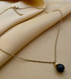 Elegant black pearl solitaire necklace on a twisted gold chain.