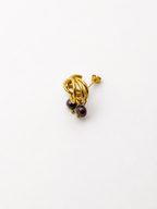 Angled view of small gold triple-hoop earrings with dark baroque freshwater pearl drops.
