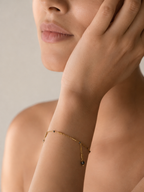 Close-up lifestyle view of a minimalist gold bracelet with 2 mm dark grey baroque freshwater pearls