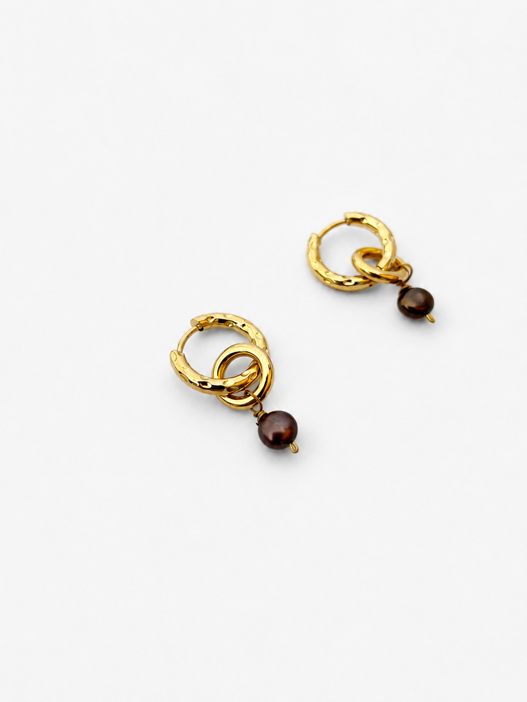 Angled view of gold double-hoop earrings with dark grey baroque freshwater pearl drops