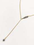 Gold lariat Y-necklace with graduated 6 mm and 2 mm dark round freshwater pearls.
