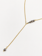 Gold lariat Y-necklace with graduated 6 mm and 2 mm dark round freshwater pearls.