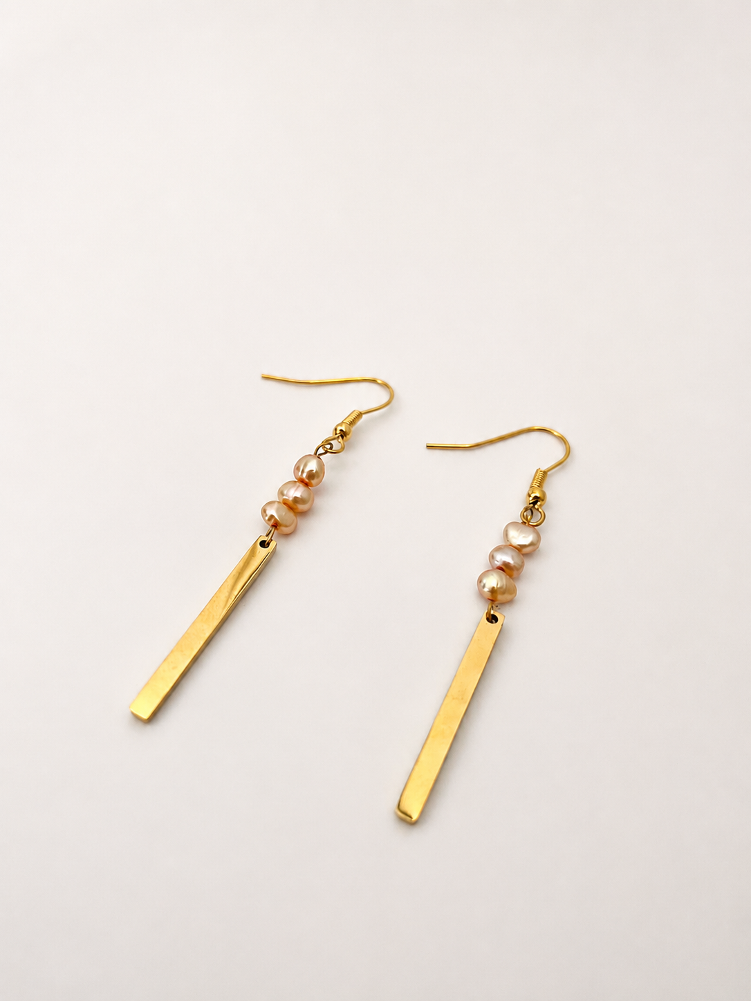 Pair of gold linear drop earrings with 4 mm gold baroque freshwater pearls and polished bar pendants
