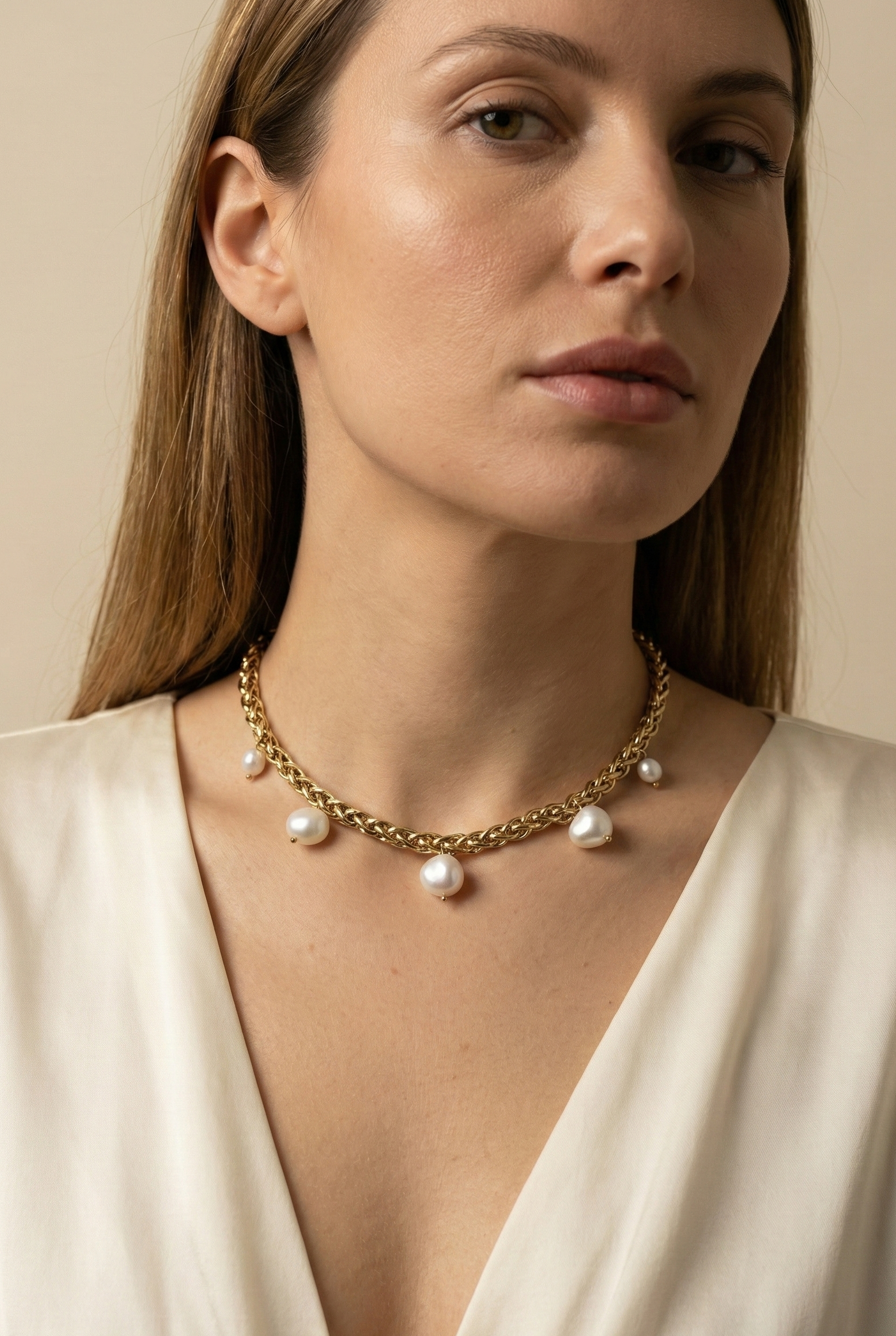 Elegant gold choker necklace featuring organic baroque pearls, shown on a model with an updo hairstyle and silk blouse