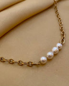 Close-up of gold link necklace featuring four high-luster oval white pearls