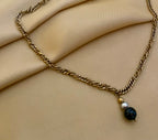 Elegant gold chain necklace with a round black pearl pendant