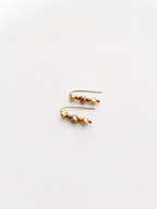 Close-up of gold ear climber earrings with organic gold and pink freshwater baroque pearls.