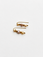Pair of gold ear climber earrings with 4 mm gold and pink baroque freshwater pearls.