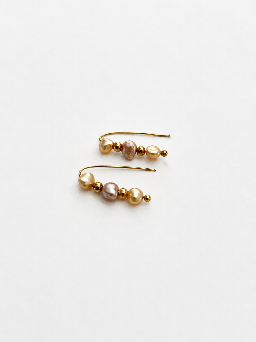 Pair of gold ear climber earrings with 4 mm gold and pink baroque freshwater pearls.