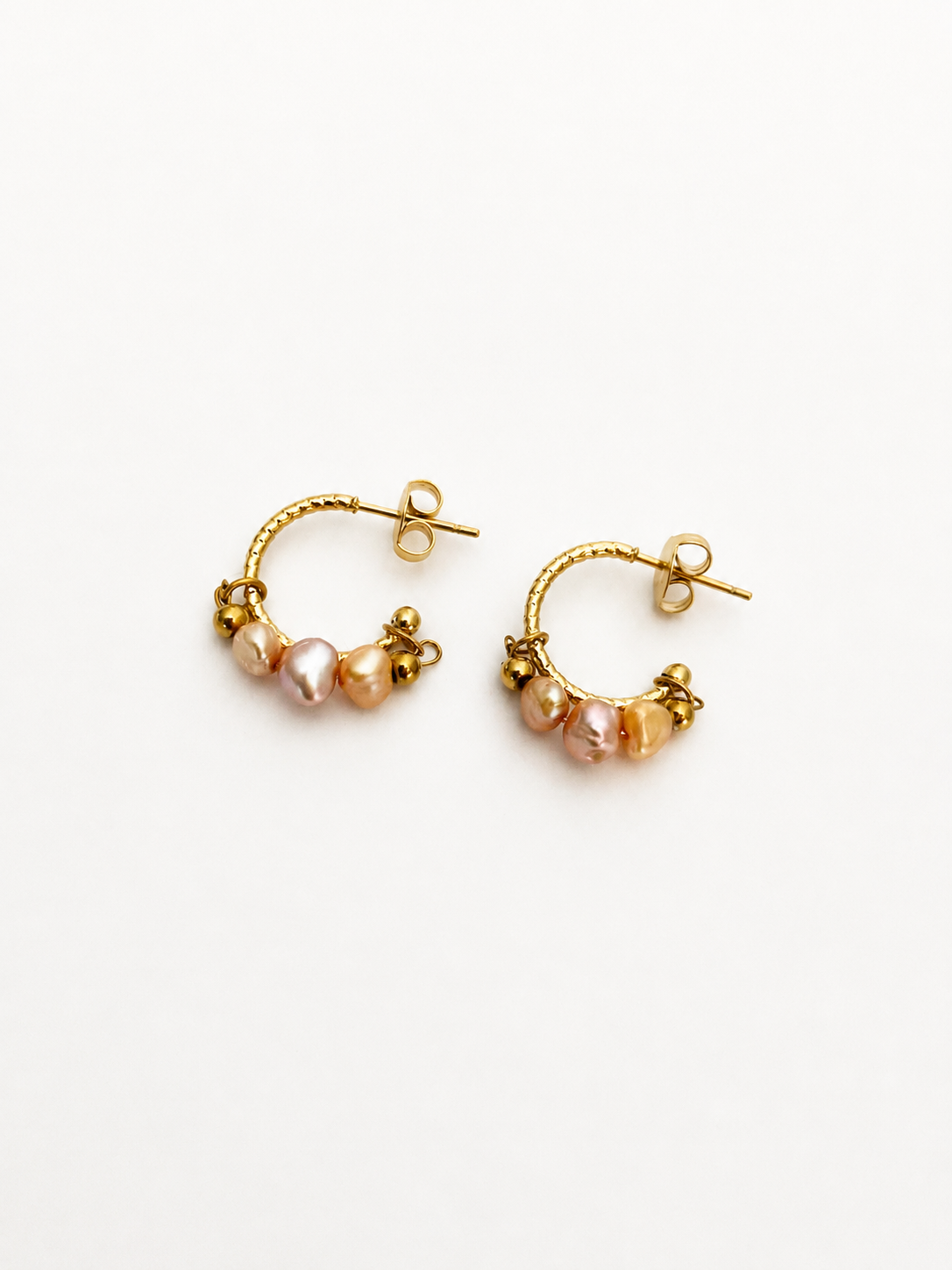 Pair of gold creole hoop earrings with 4 mm pink and gold baroque freshwater pearls and polished gold beads.