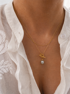 Woman wearing a gold lariat Y-necklace with a 10 mm grey baroque freshwater pearl pendant