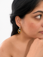 Woman wearing a two-tone gold and silver hoop earring with a grey freshwater pearl drop.