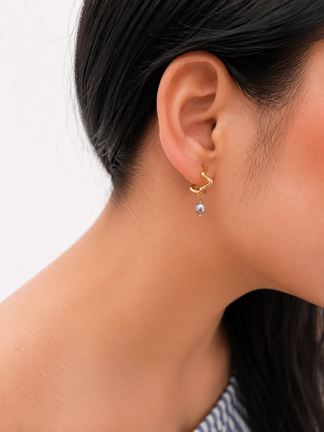 Side view of a wave-inspired gold creole earring with a 4 mm grey baroque freshwater pearl drop
