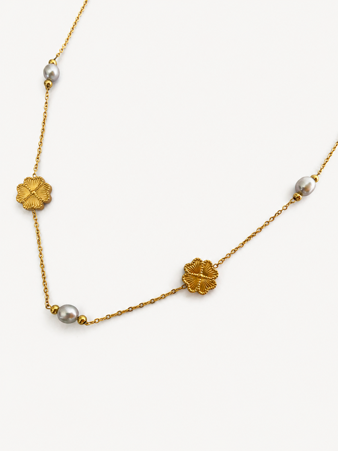 Gold Clover Bloom necklace with grey oval freshwater pearls and sculpted four-leaf clover stations