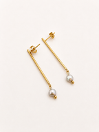 Back and angled view of gold linear drop earrings with 4 mm grey freshwater pearls and stud posts