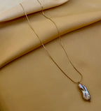 Organic grey baroque pearl necklace featuring a high-luster Keshi pearl suspended on a fine gold chain. Minimalist jewelry styling
