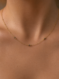 Close-up of a delicate gold necklace with 2 mm grey Keshi freshwater pearls and polished gold bead accents.