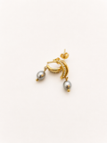 Angled view of gold half moon huggie earrings with 6 mm oval grey freshwater pearls and cubic zirconia