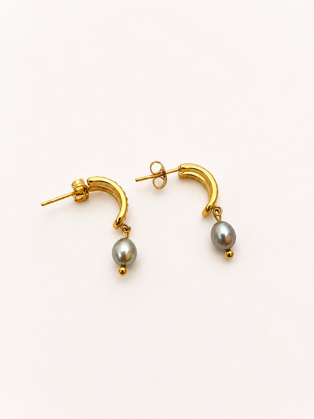 Back view of gold half moon huggie earrings with 6 mm oval grey freshwater pearl drops