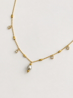 Close-up of a gold chain necklace with a 6 mm oval grey freshwater pearl and brilliant-cut cubic zirconia accents