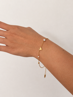 Gold chain heart bracelet with a grey pearl, small white pearl and adjustable extender on the wrist
