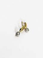 Angled close-up of gold pandan leaf earrings with organic grey baroque freshwater pearl drops