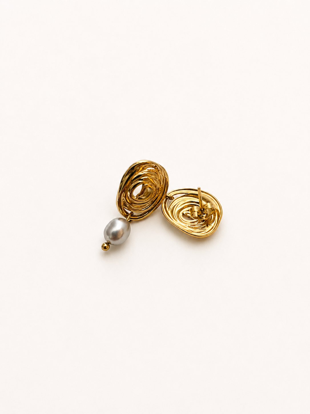 Back and angled view of gold spiral stud earrings with oval grey freshwater pearl drops.