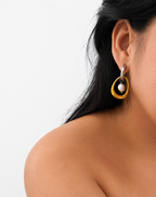 Side view of a two-tone gold and silver hoop earring with a grey baroque freshwater pearl worn on the ear.
