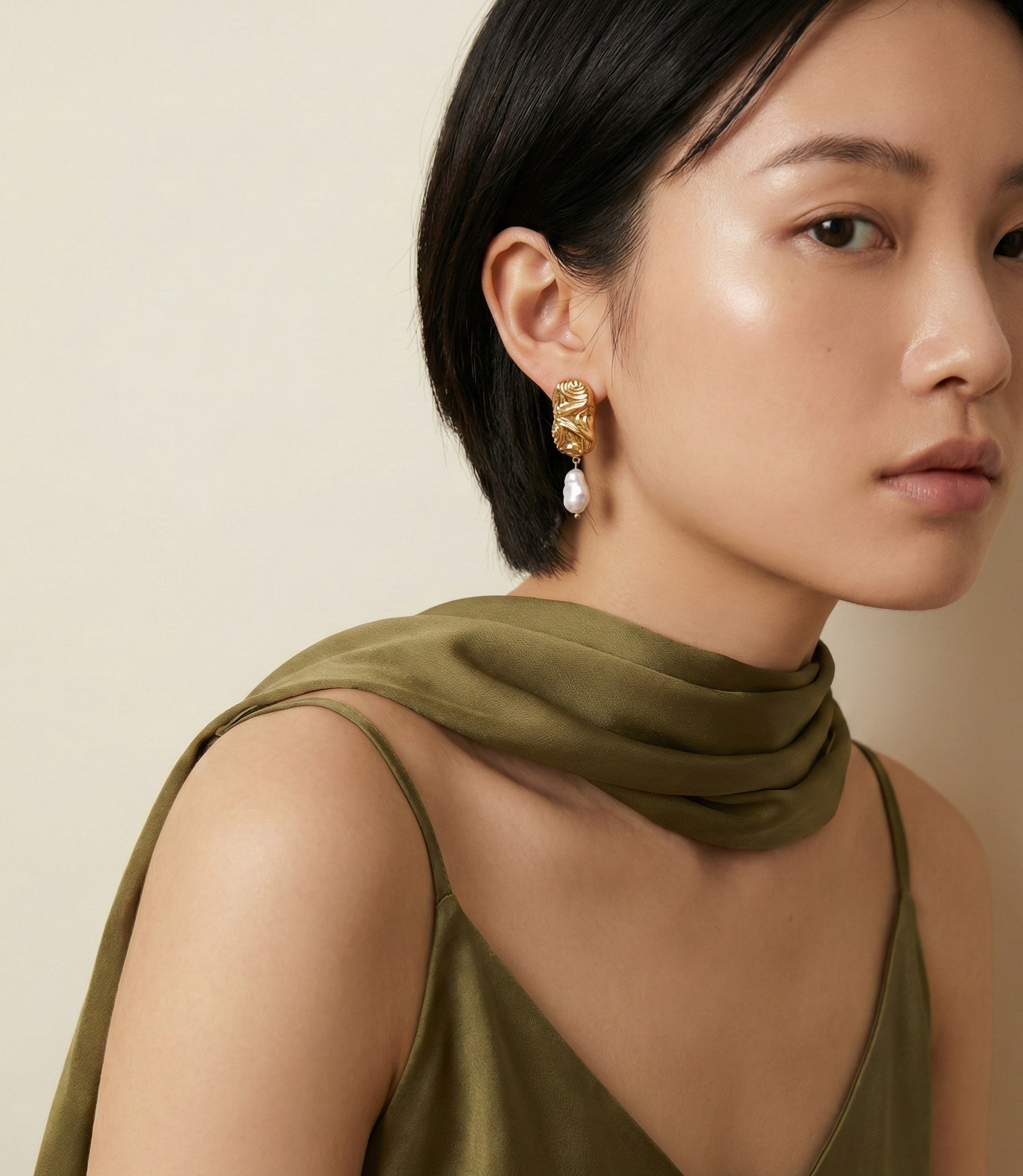 Close-up of an asian model wearing sculptured aztec organic 18k gold earrings with japanese keshi pearls