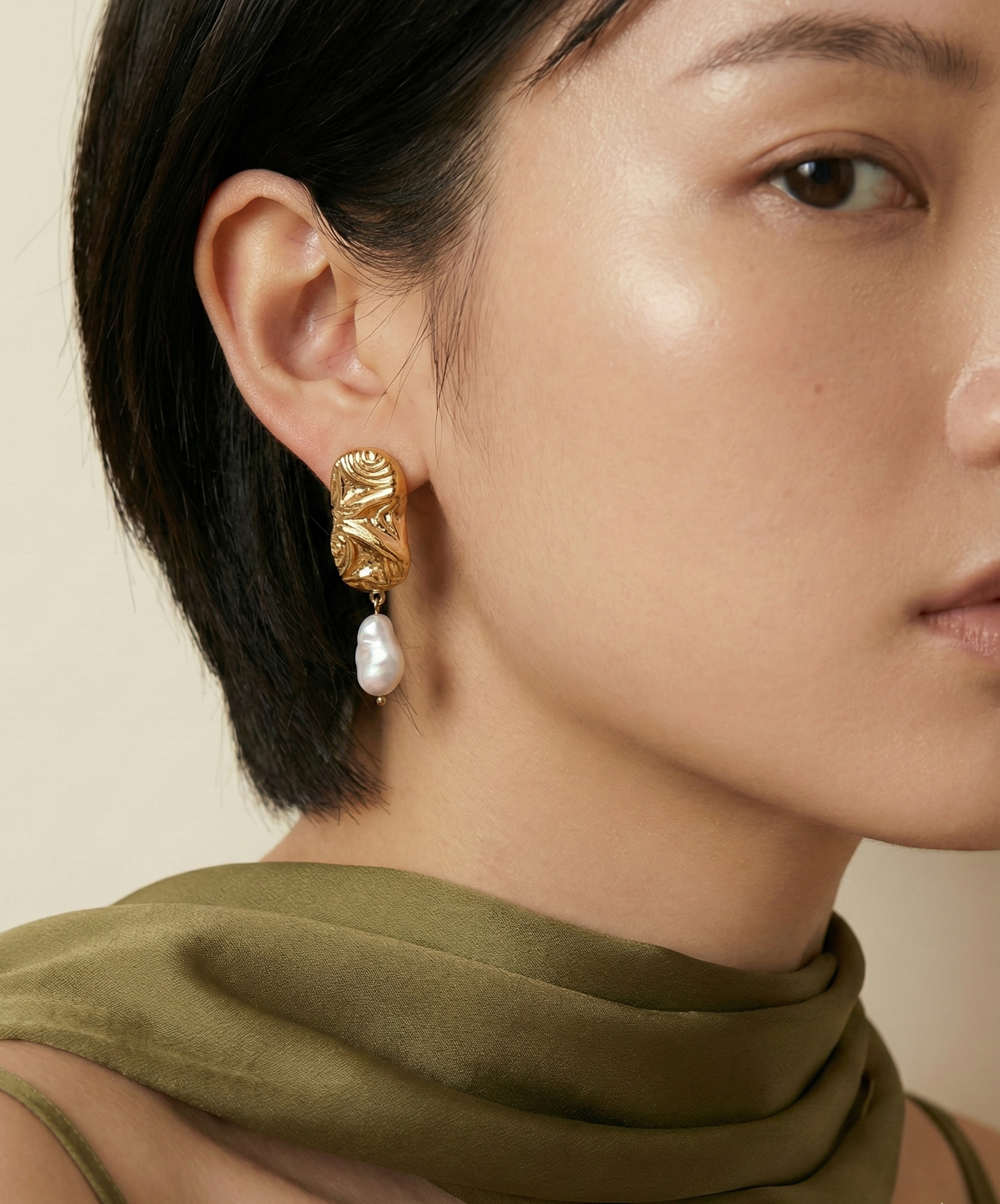 Close-up of an asian model wearing sculptured aztec organic 18k gold earrings with japanese keshi pearls