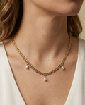 Model wearing a dainty gold wheat chain necklace with baroque pearl pendants, styled with a white silk top for a minimalist bridal or evening look