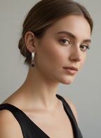 Woman wearing Naomi modern gold drop earrings with round black pearls. Elegant architectural jewelry styled for evening or professional wear