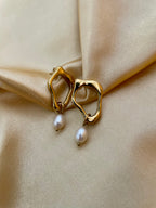 woman wearing sculptural gold earrings with a delicate freshwater pearl drop, ideal for weddings, office and casual night outs