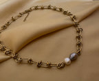 Close-up of a AAA grade baroque pearl necklace featuring a duo of white and silver-grey pearls on a chunky gold paperclip chain