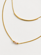 Gold layered Arc necklace with a curved bar and 4 mm oval pink freshwater pearl framed by gold beads