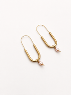 Angled view of gold paperlink earrings with oval pink freshwater pearl drops
