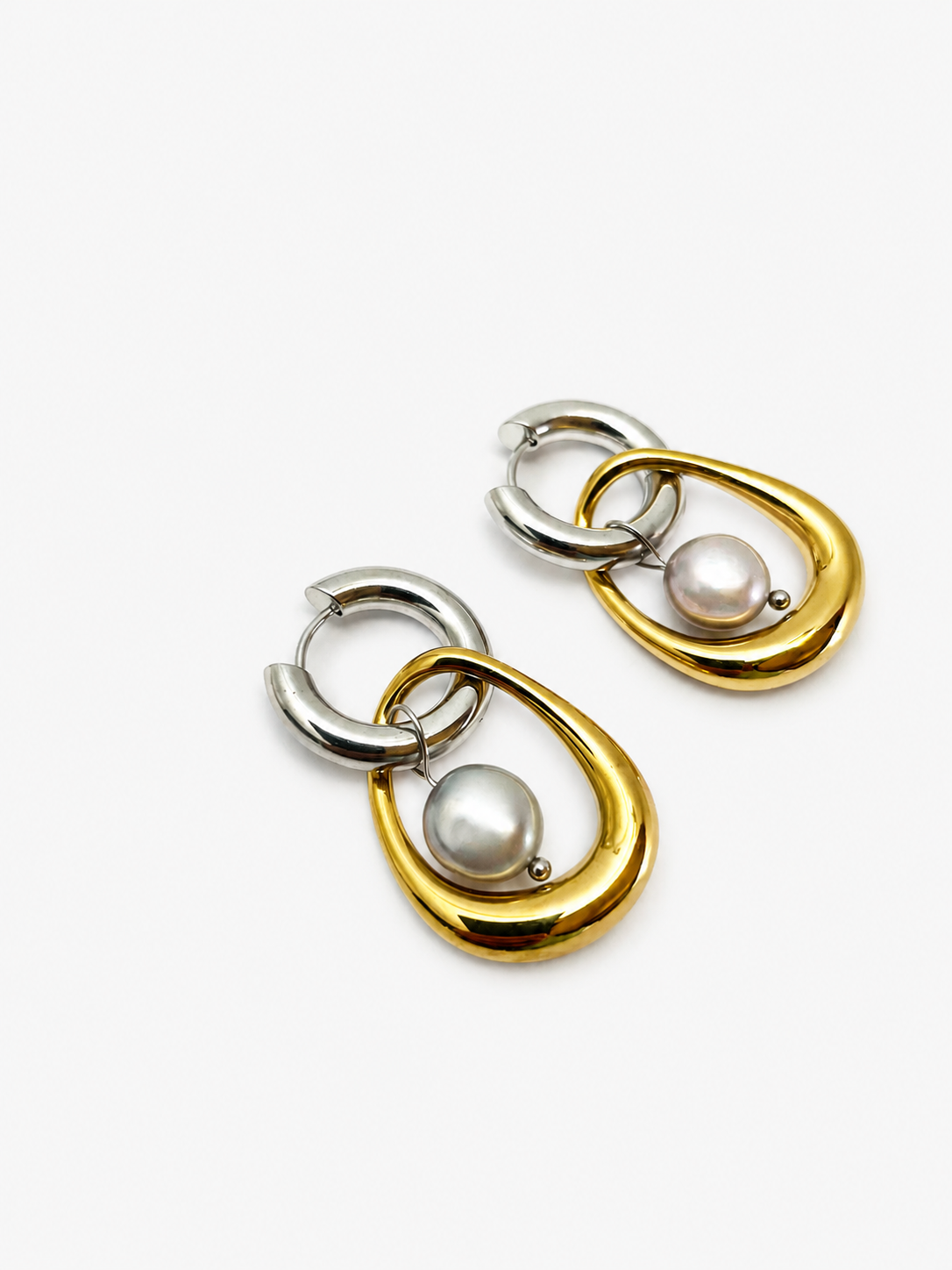 Angled close-up of two-tone hoop earrings with organic grey baroque freshwater pearl drops.