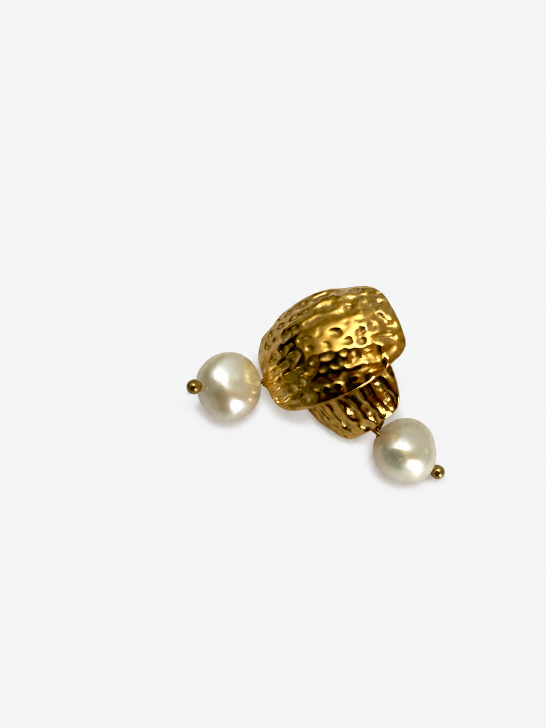 Angled close-up of textured gold earrings with organic white baroque pearl drops