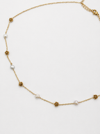 Gold station necklace with 4 mm white baroque freshwater pearls alternating with sculpted rose details