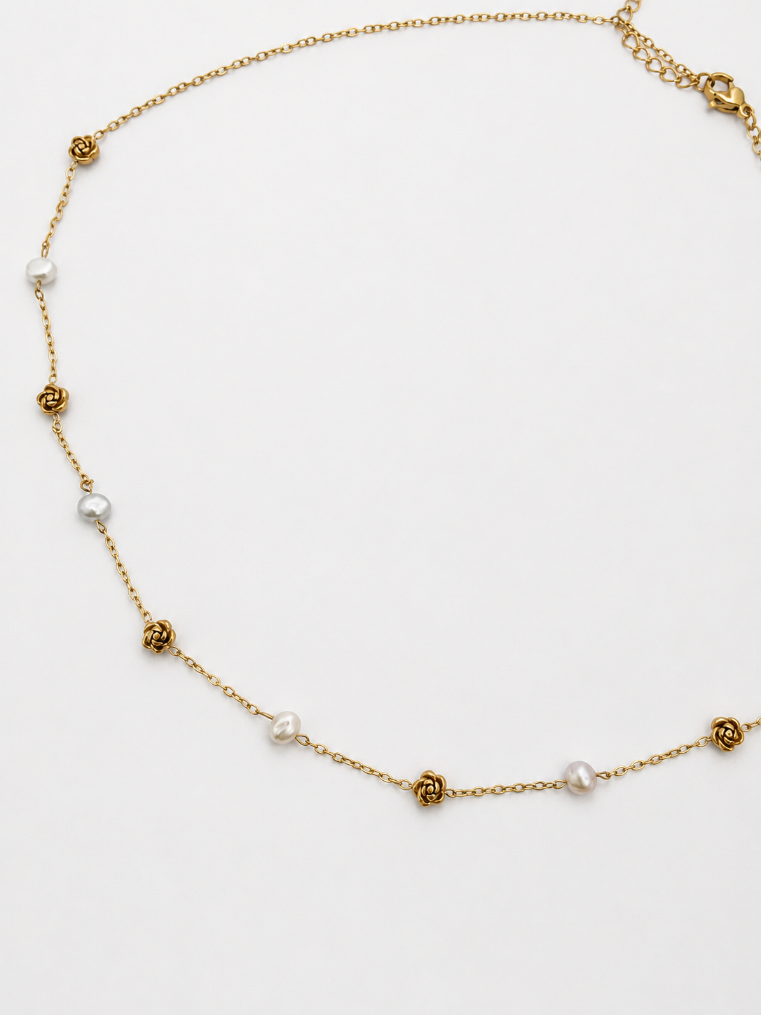 Gold station necklace with 4 mm white baroque freshwater pearls alternating with sculpted rose details