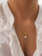 Woman wearing a gold lariat Y-necklace with a 10 mm white baroque freshwater pearl pendant