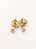 Back view of gold love knot drop earrings with white baroque freshwater pearl pendants and stud posts