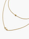 Close-up of a gold double-layer necklace with a 4–6 mm white baroque freshwater pearl and polished gold beads